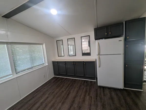a kitchen with cabinets and wooden floor