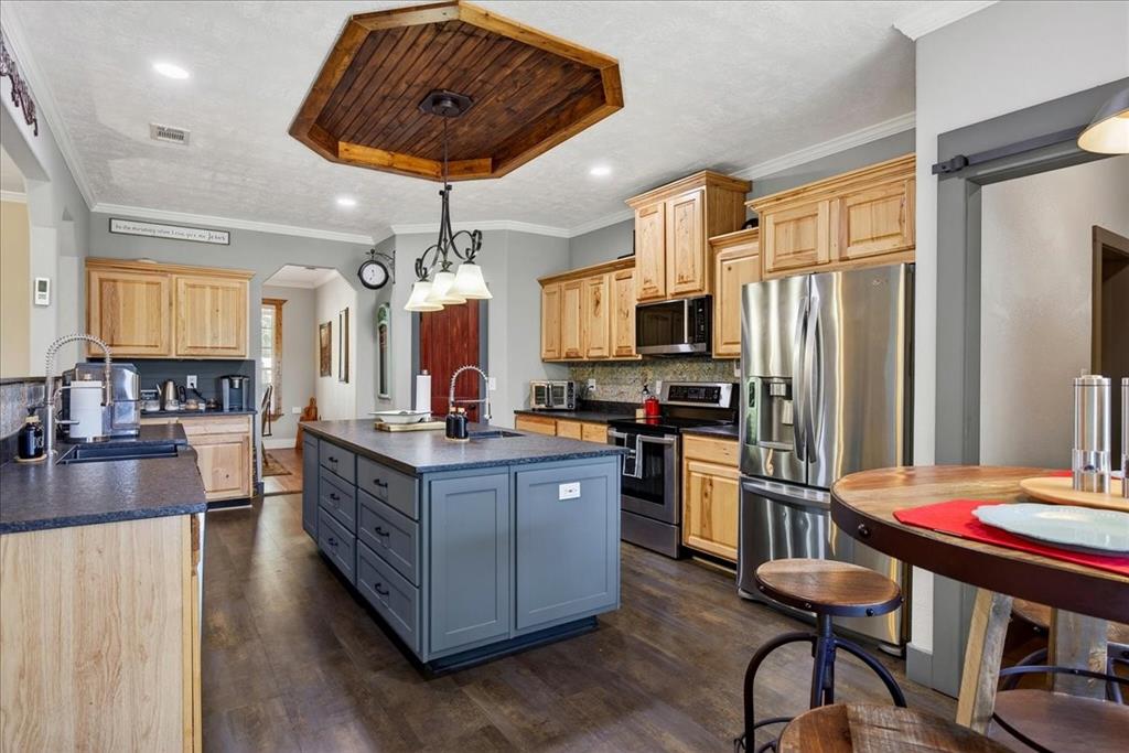 11591 Farm To Market 59 Athens, TX 75751 - Photo 6 of 40 Spacious kitchen featuring a central island with integrated storage, wood-finish flooring, recessed lighting, and a wood-paneled ceiling accent. Open to the living, granite counters, Hickory cabinets, tile back splash, double black metal farm sink, coffee bar with small sink. large pantry and breakfast area.