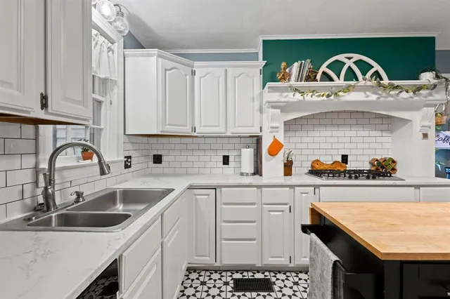 a kitchen with stainless steel appliances granite countertop a sink stove and cabinets