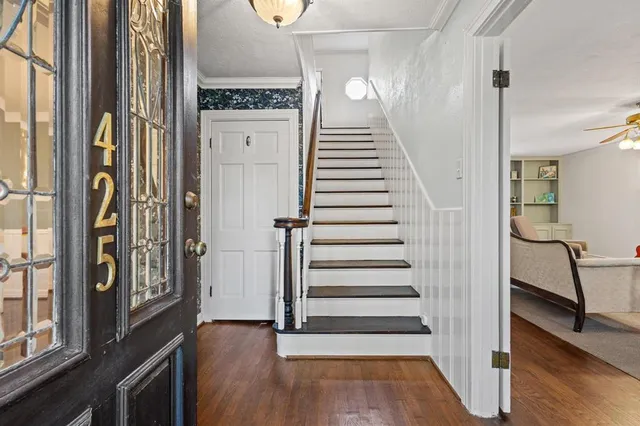 a view of a hallway with wooden floor and staircase