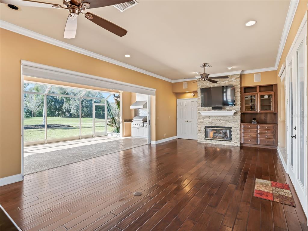 1412 Meadow View Way Lady Lake, FL 32159 - Photo 14 of 37 a view of a big room with wooden floor a fireplace and windows