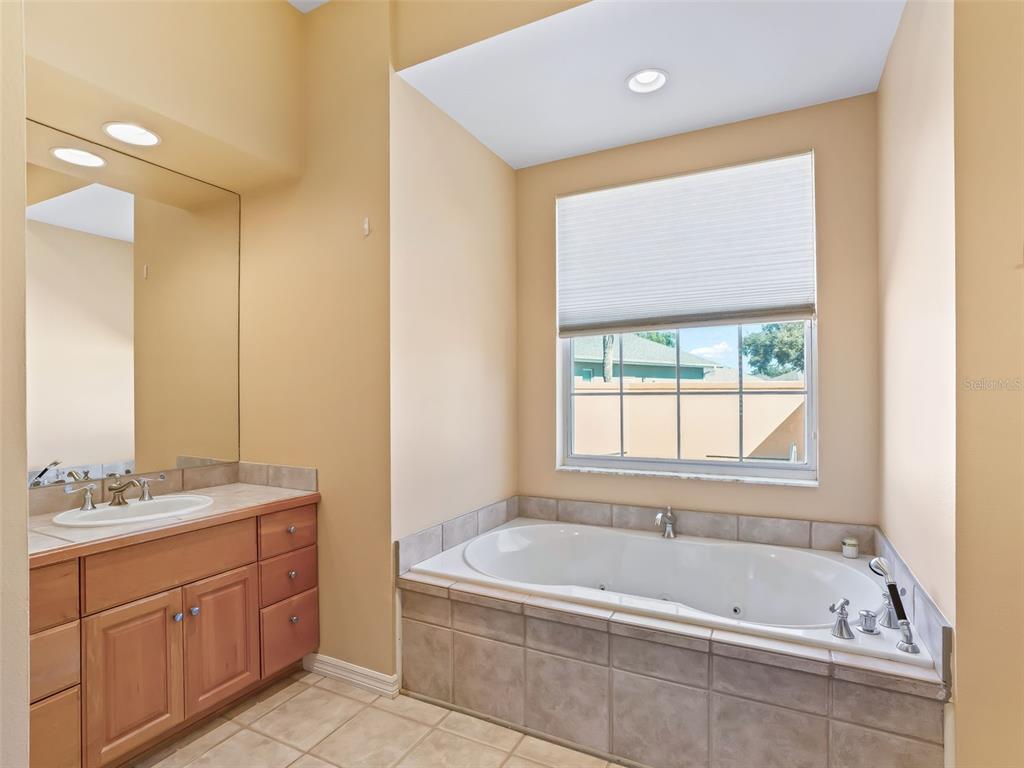 1412 Meadow View Way Lady Lake, FL 32159 - Photo 21 of 37 a bathroom with a tub sink and mirror
