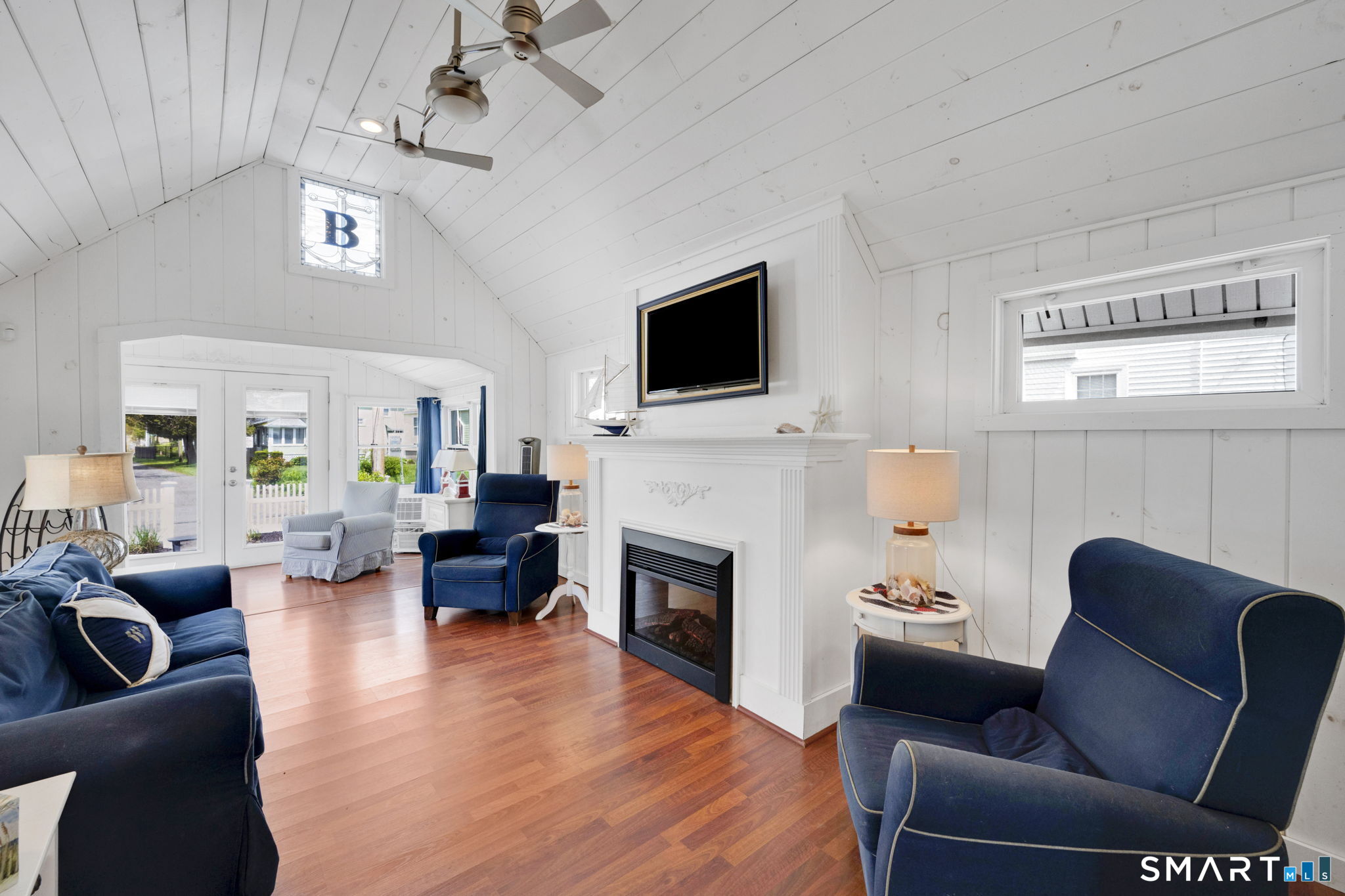 96 Chalker Beach Road Old Saybrook, CT 06475 - Photo 22 of 33 a living room with furniture a fireplace and a flat screen tv