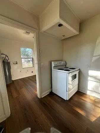 a view of a kitchen with wooden floor and electronic appliances
