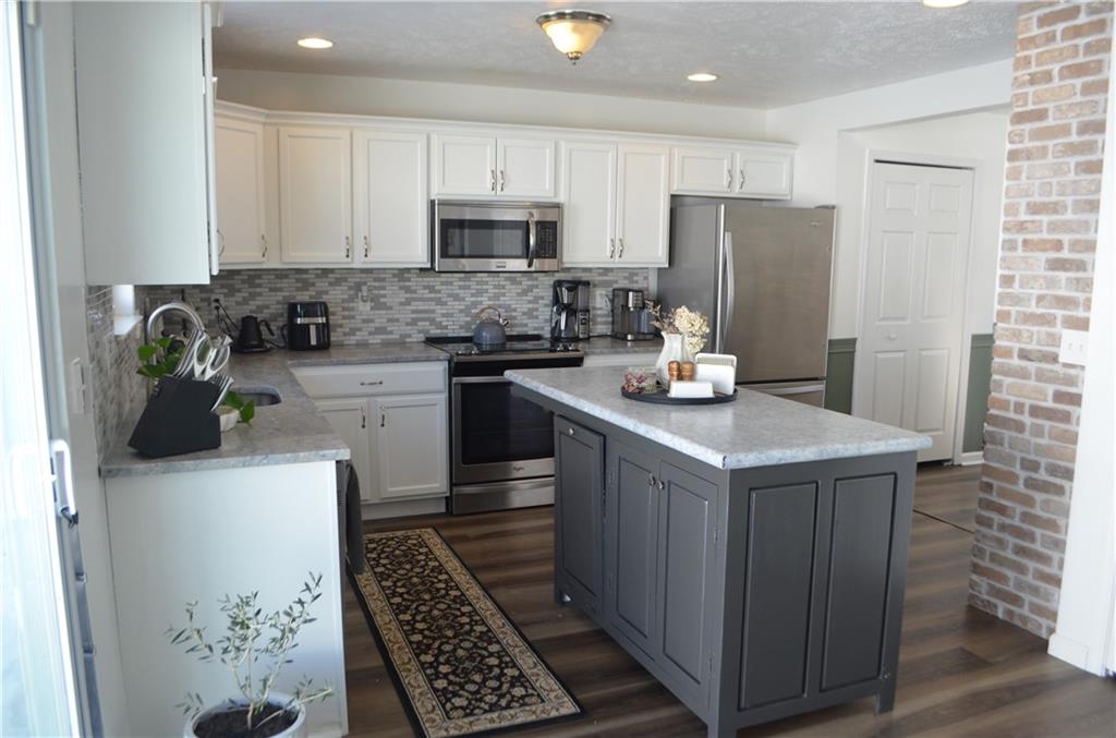 515 Galileo Drive Rostraver Township, PA 15012 - Photo 9 of 43 a kitchen with stainless steel appliances granite countertop a stove a refrigerator a sink a counter space and cabinets