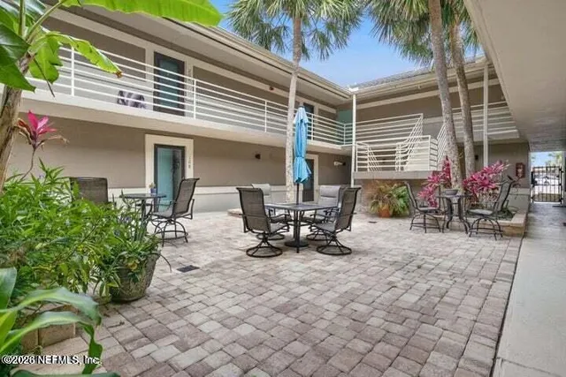 a view of a patio with a table and chairs under an umbrella