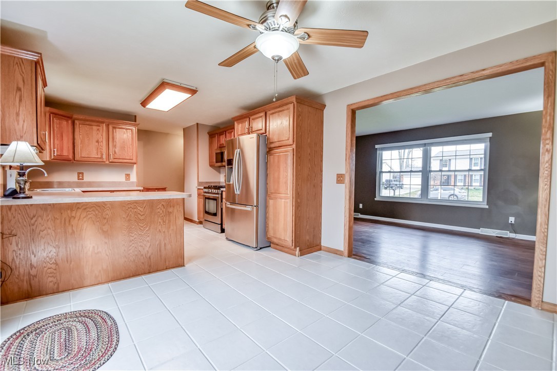5618 Dolphin Road Mentor, OH 44060 - Photo 9 of 46 Kitchen with appliances with stainless steel finishes, light countertops, a peninsula, ceiling fan, and light tile patterned flooring