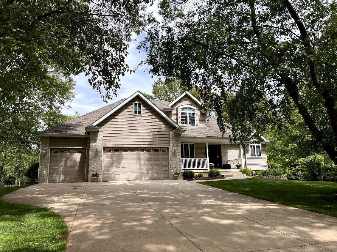 a front view of a house with a garden and trees