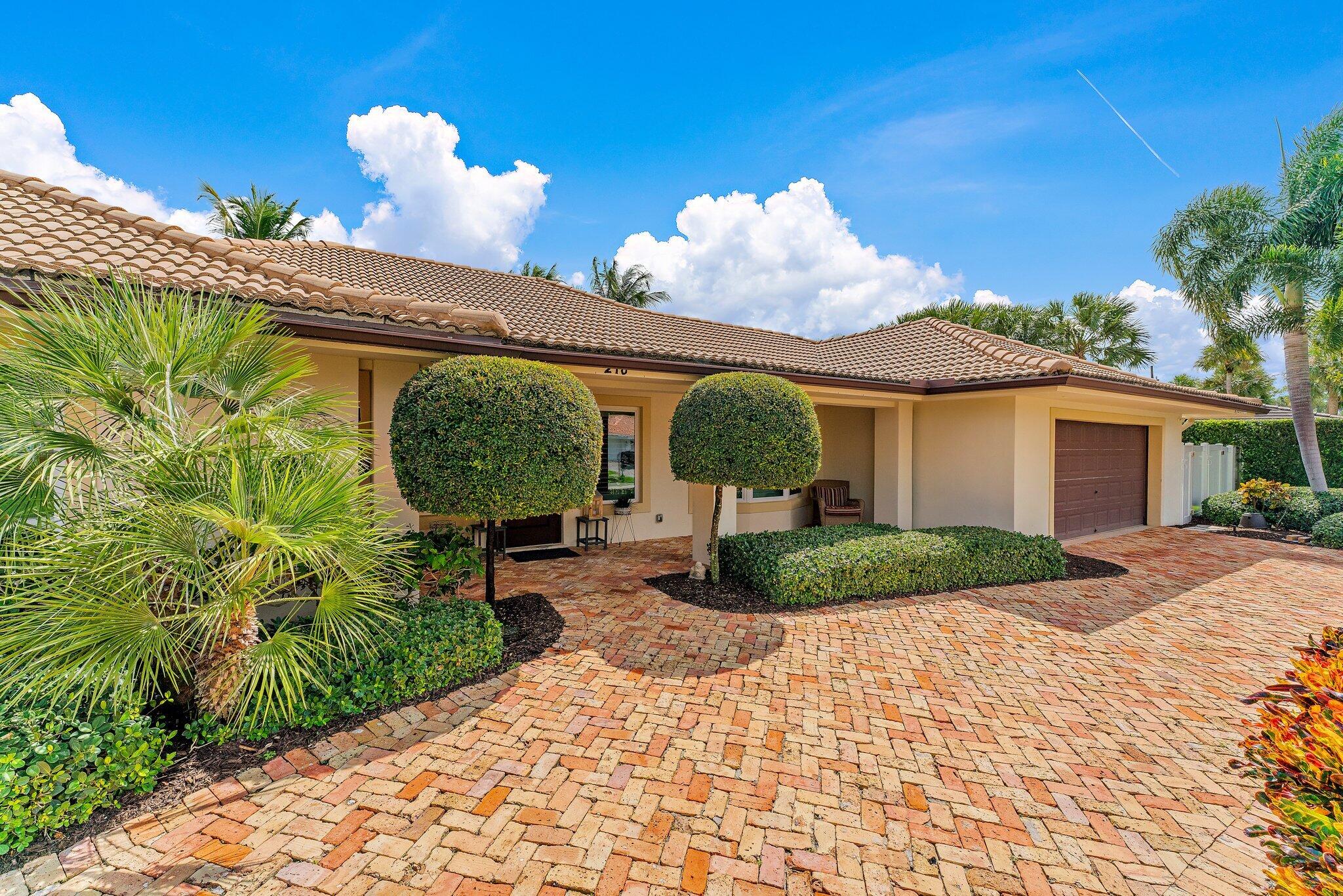 210 Golfview Drive Tequesta, FL 33469 - Photo 2 of 27 a view of a house with a yard and a garden