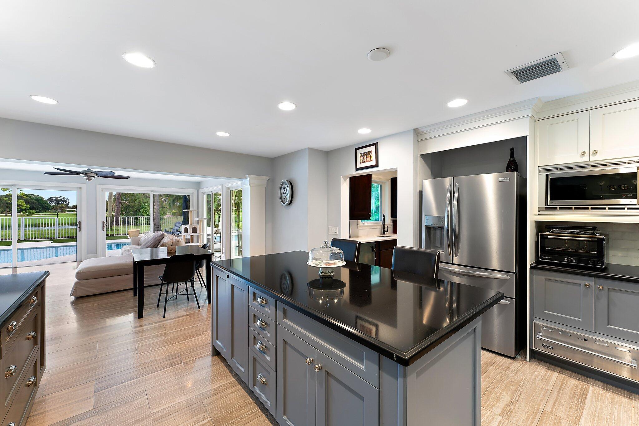 210 Golfview Drive Tequesta, FL 33469 - Photo 8 of 27 a kitchen with granite countertop a center island a sink dishwasher stove and refrigerator
