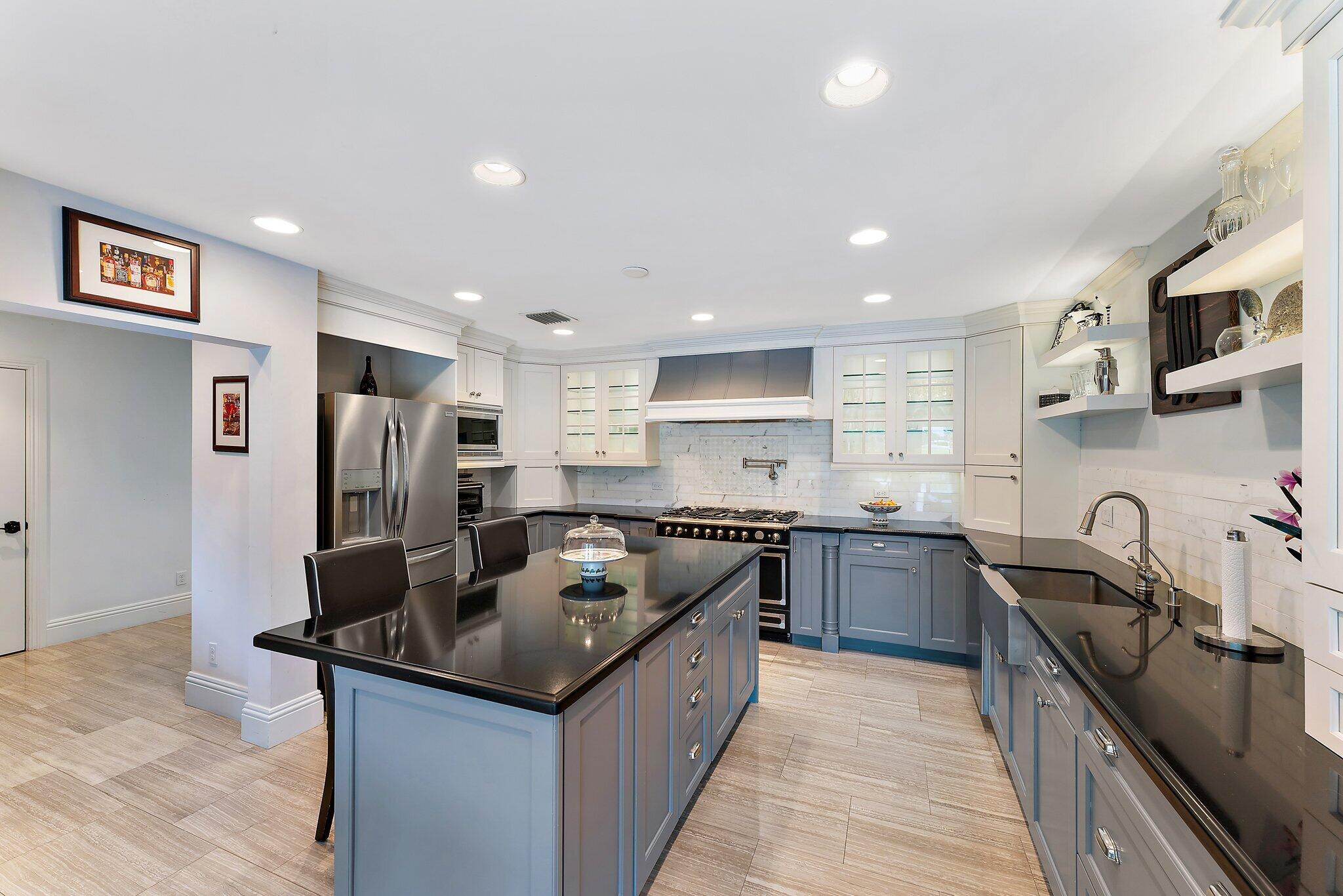 210 Golfview Drive Tequesta, FL 33469 - Photo 10 of 27 a kitchen with stainless steel appliances granite countertop a sink stove and refrigerator
