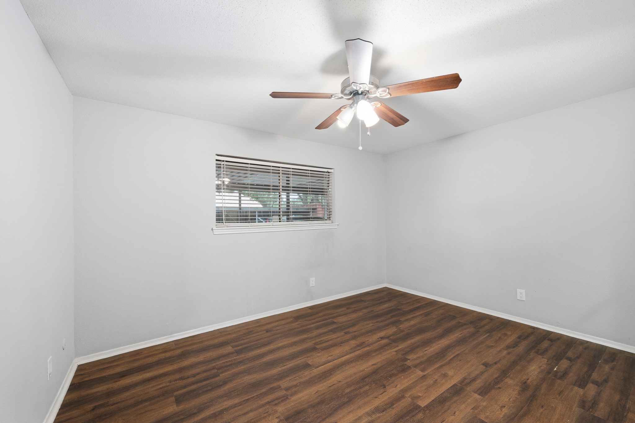 11550 Chimney Rock Road, Unit 133 Houston, TX 77035 - Photo 18 of 40 Bedroom featuring sleek wood flooring, a modern ceiling fan, and a large window for natural light. Notice there is no carpet in this home.