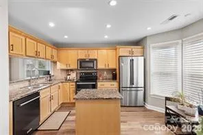 a kitchen with stainless steel appliances granite countertop a refrigerator a stove and a sink