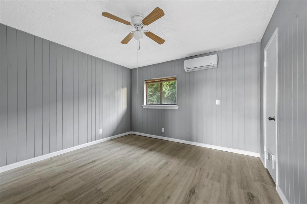 1585 North Mill Street, Unit 5 Lewisville, TX 75057 - Photo 11 of 17 an empty room with wooden floor and windows