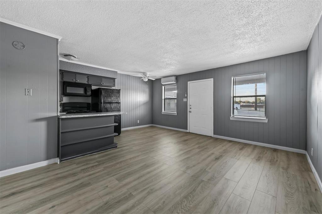 1585 North Mill Street, Unit 5 Lewisville, TX 75057 - Photo 2 of 17 an empty room with wooden floor closet and windows