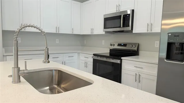 a kitchen with stainless steel appliances granite countertop a sink and a stove