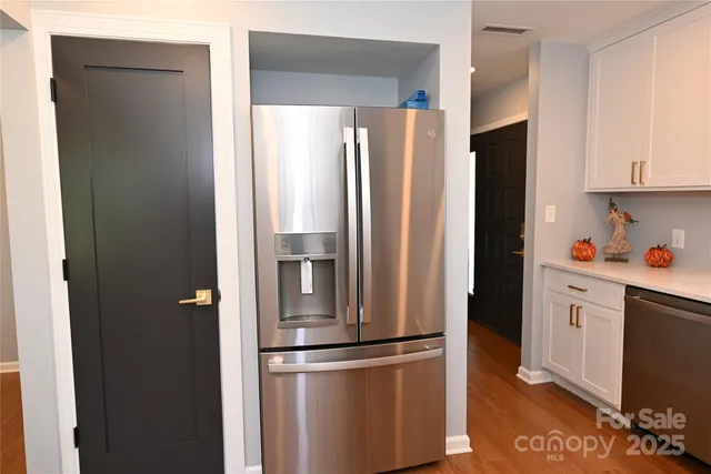 a metallic refrigerator freezer sitting in a kitchen