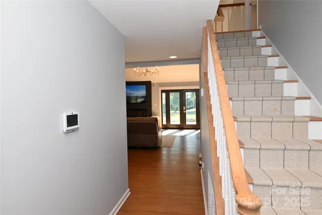 a view of a hallway with wooden floor and a bathroom