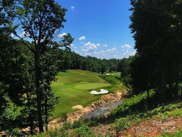 a view of a house with pool and chairs under an umbrella