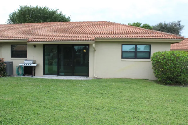 a view of a house with potted plants and a yard