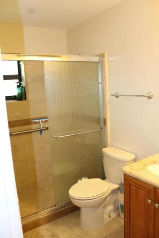 a white toilet sitting next to a shower