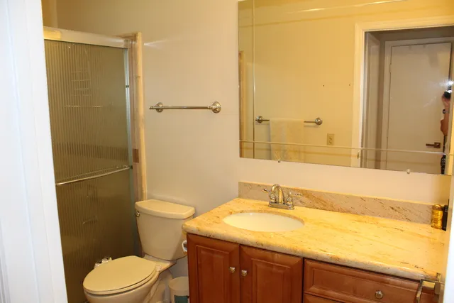 a bathroom with a sink a toilet and shower