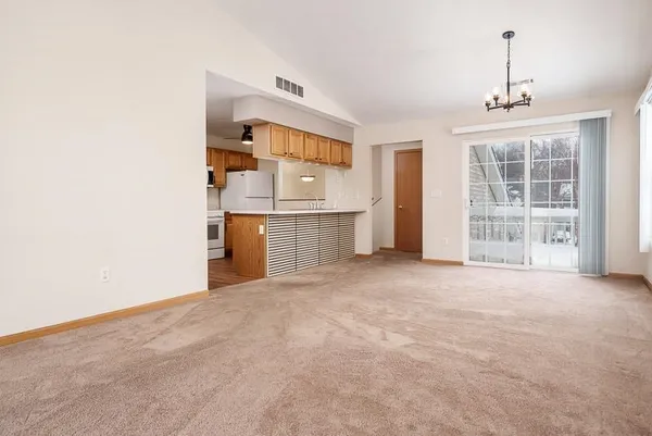 an empty room with cabinet and windows