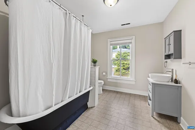 a bathroom with a sink a bathtub and a window