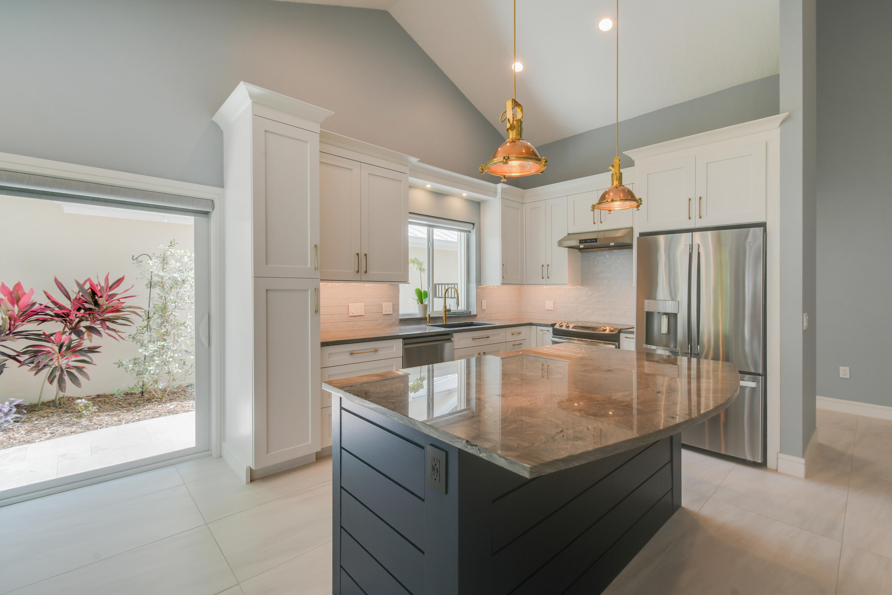438 River Edge Road Jupiter, FL 33477 - Photo 19 of 80 a kitchen with stainless steel appliances granite countertop a sink dishwasher and a refrigerator with wooden floor