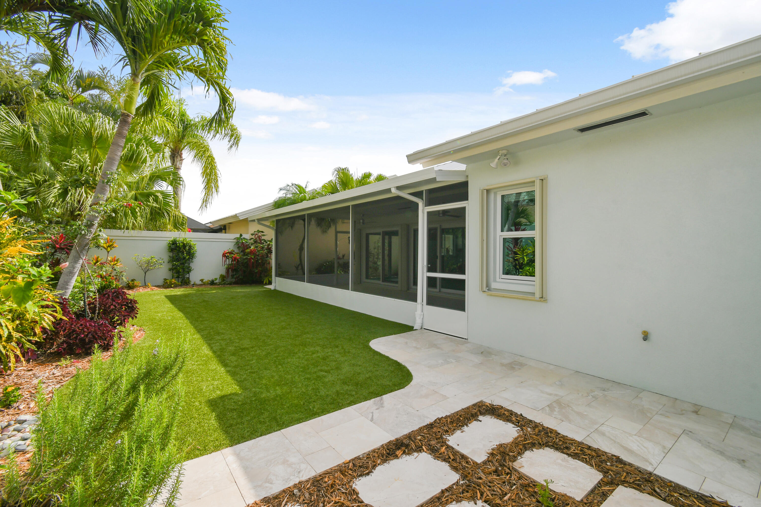 438 River Edge Road Jupiter, FL 33477 - Photo 53 of 80 a view of a white house with a big yard and potted plants