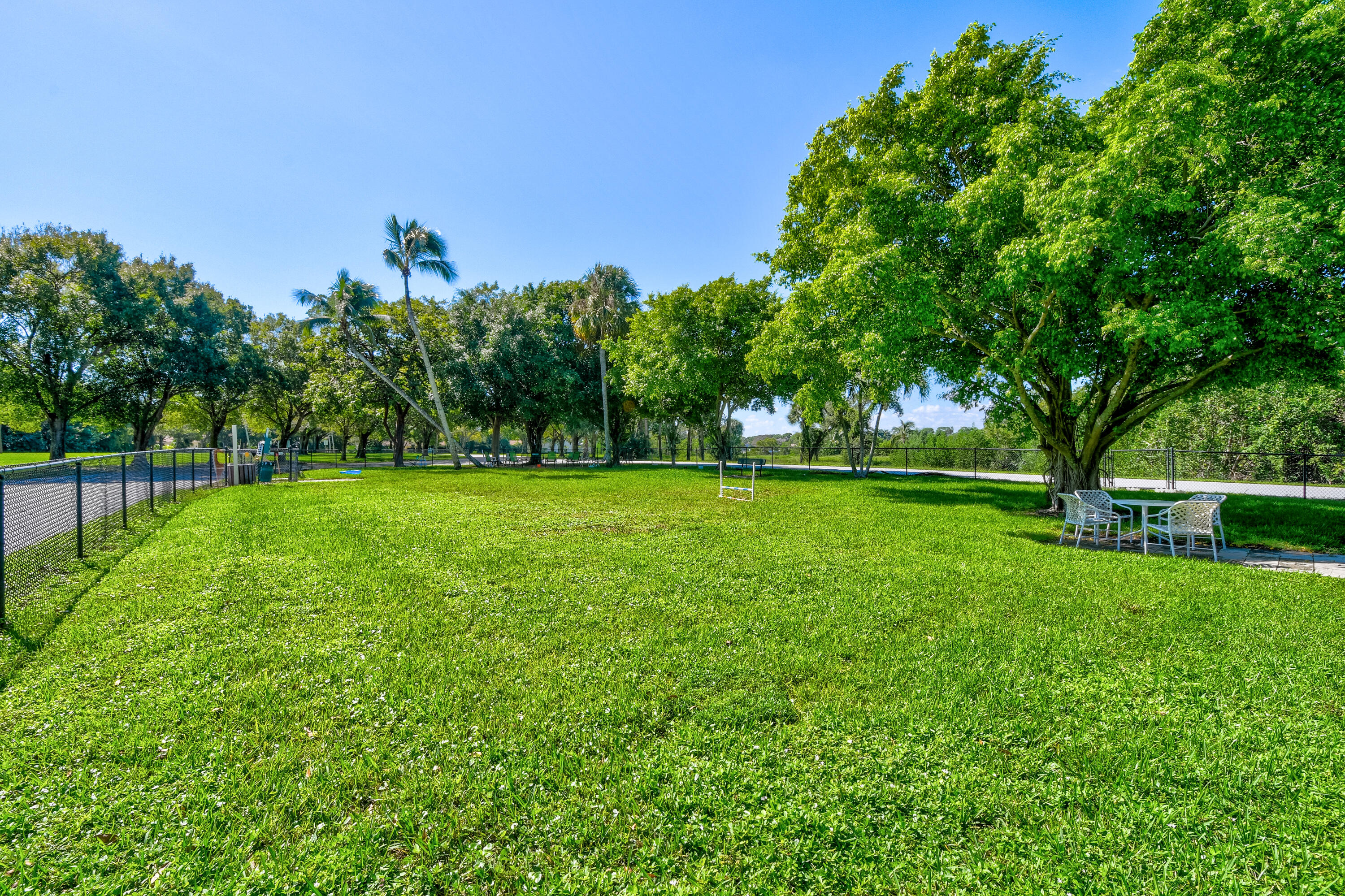 438 River Edge Road Jupiter, FL 33477 - Photo 76 of 80 a view of a green field with trees in the background