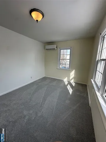 an empty room with windows and ceiling fan