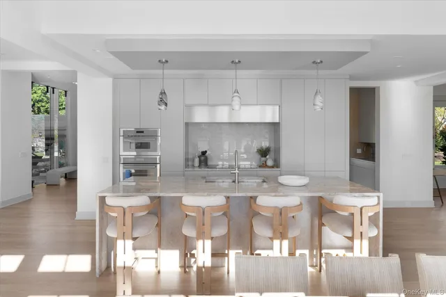 a kitchen with stainless steel appliances kitchen island granite countertop a stove and white cabinets