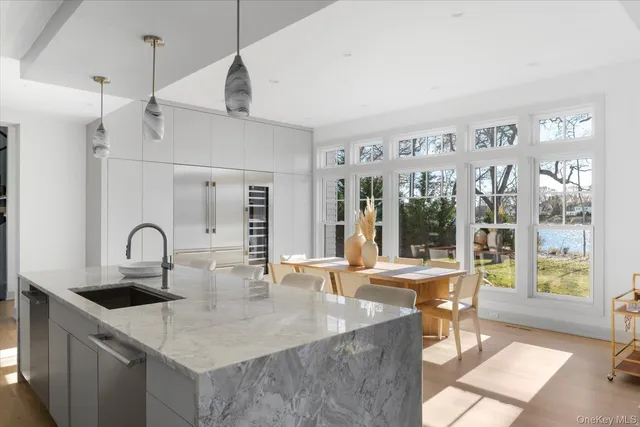 a kitchen with granite countertop a sink and white cabinets next to a window
