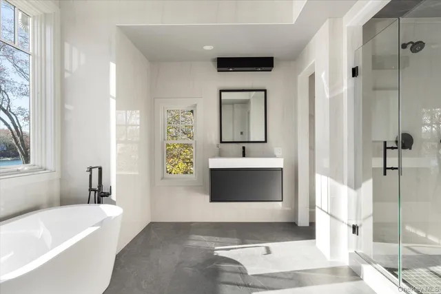 a bathroom with a bathtub sink and mirror