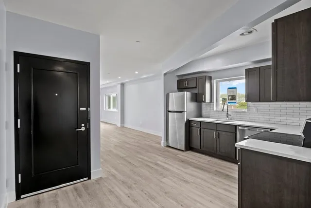 a kitchen with stainless steel appliances granite countertop a refrigerator and a sink
