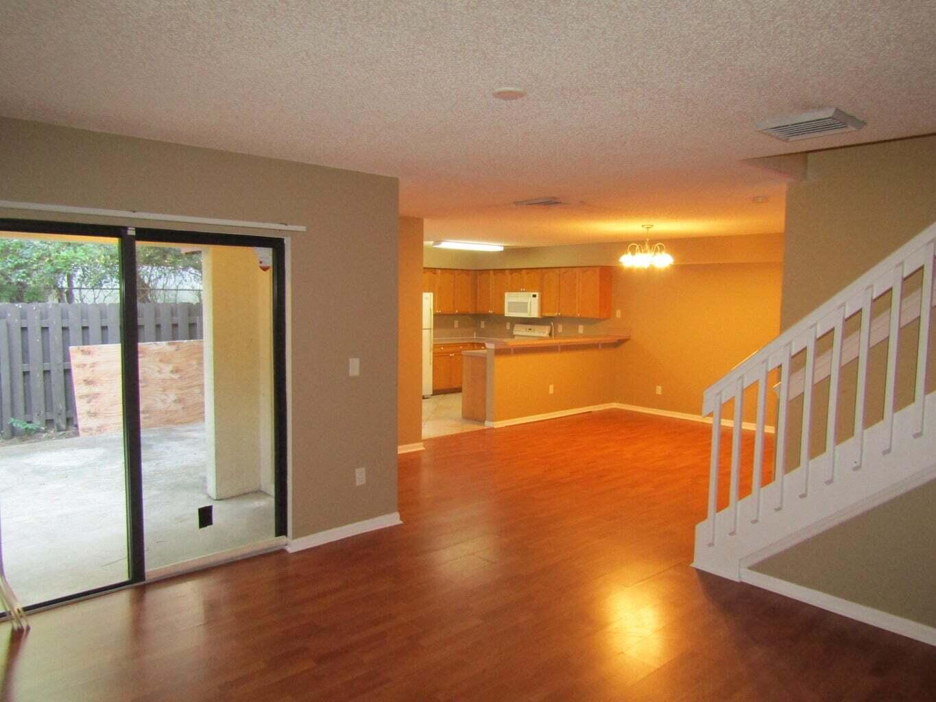 2212 White Pine Circle, Unit B Greenacres, FL 33415 - Photo 3 of 9 a view of an empty room with wooden floor and a window