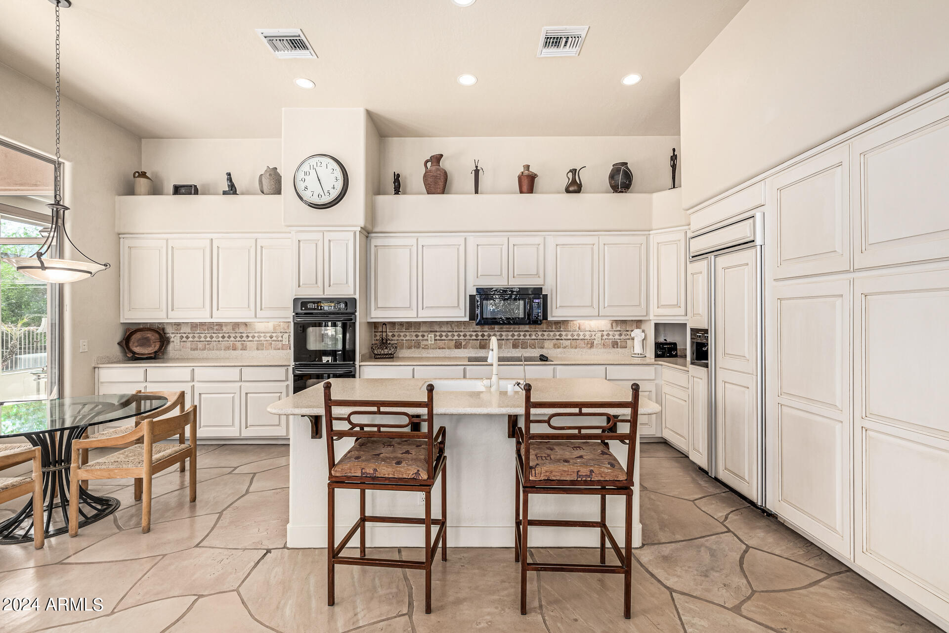 6437 North 28th Street Phoenix, AZ 85016 - Photo 16 of 53 a kitchen with white cabinets and chairs