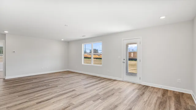 a view of kitchen with kitchen island white cabinets and wooden floor
