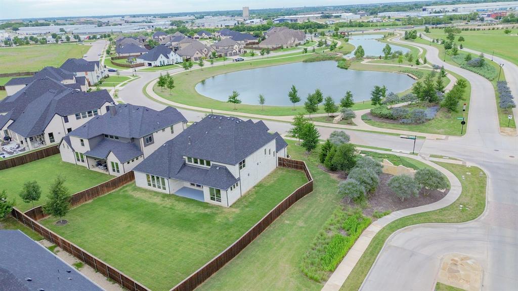 1316 Limestone Ridge Road Mansfield, TX 76063 - Photo 4 of 40 Aerial perspective showcasing a modern residential property with a spacious backyard, situated within a community featuring multiple ponds and paved walking paths