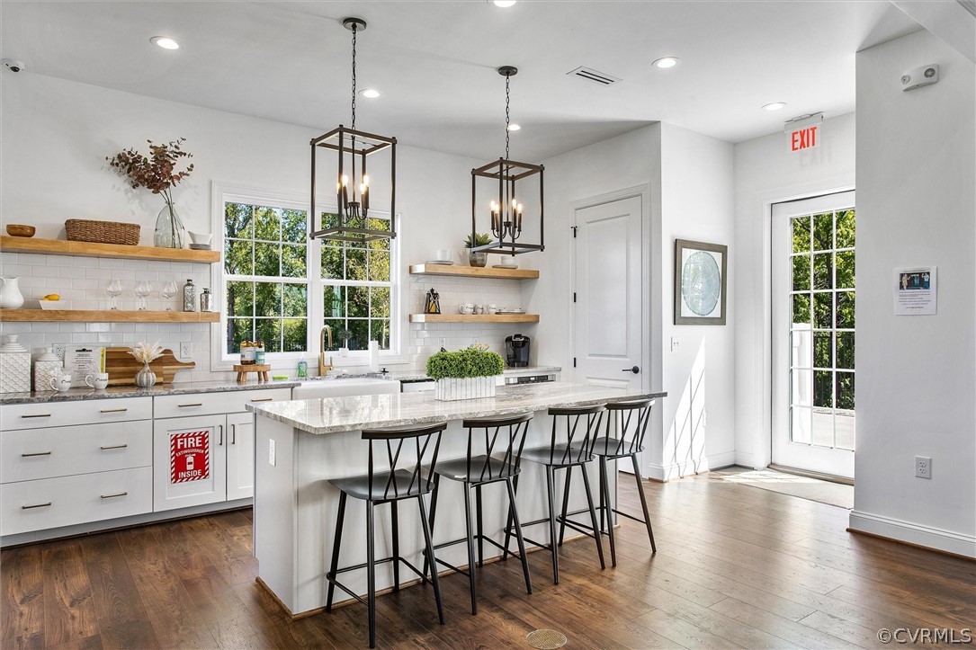 12233 Bremner Ridge Circle Manakin-Sabot, VA 23103 - Photo 48 of 49 a kitchen with stainless steel appliances kitchen island granite countertop a table chairs in it and wooden floors