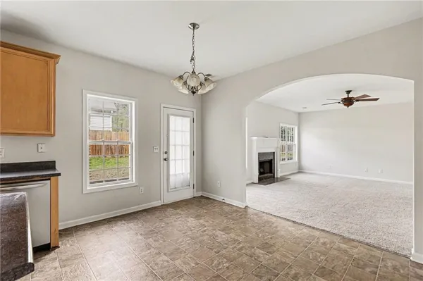 a view of a livingroom with a chandelier fan and windows