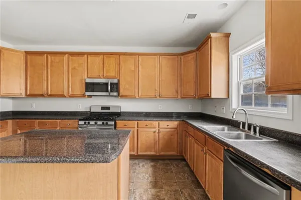 a kitchen with stainless steel appliances granite countertop a sink stove and cabinets