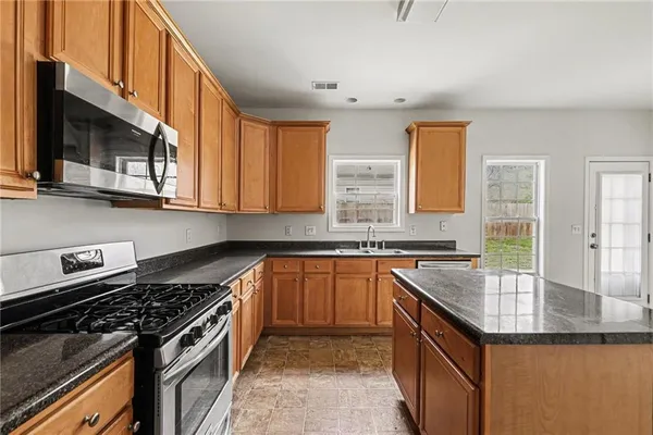 a kitchen with stainless steel appliances granite countertop a sink stove and cabinets