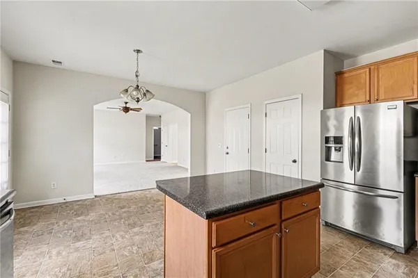 a kitchen with kitchen island a counter top space cabinets and stainless steel appliances