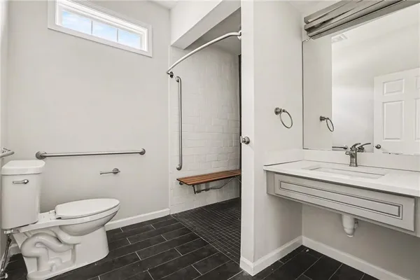 a bathroom with a sink a toilet and shower