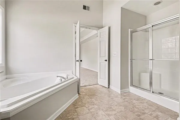 a spacious bathroom with a bathtub and a shower