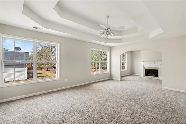 a view of an empty room with a fireplace and a window