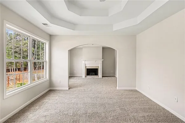 an empty room with windows and a fireplace