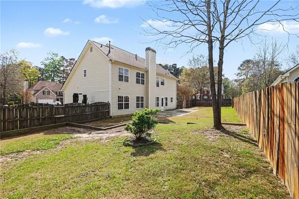 a view of a house with backyard and tree